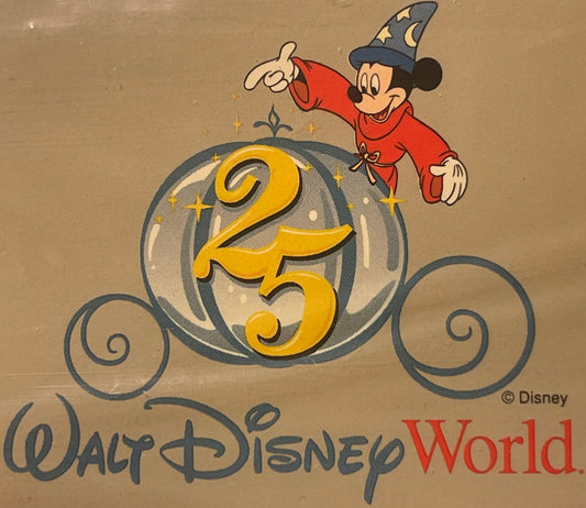 Vintage Walt Disney World 25th Anniversary Sorcerer Mickey luggage label showing Mickey in red robe and wizard hat on tan car