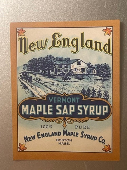 Vintage maple syrup label with farmhouse illustration, orange maple leaf corners, and brown border mounted on tan cardboard b