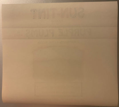 Aged peach-colored fruit crate label with faded text, folded creases visible, photographed flat against neutral background