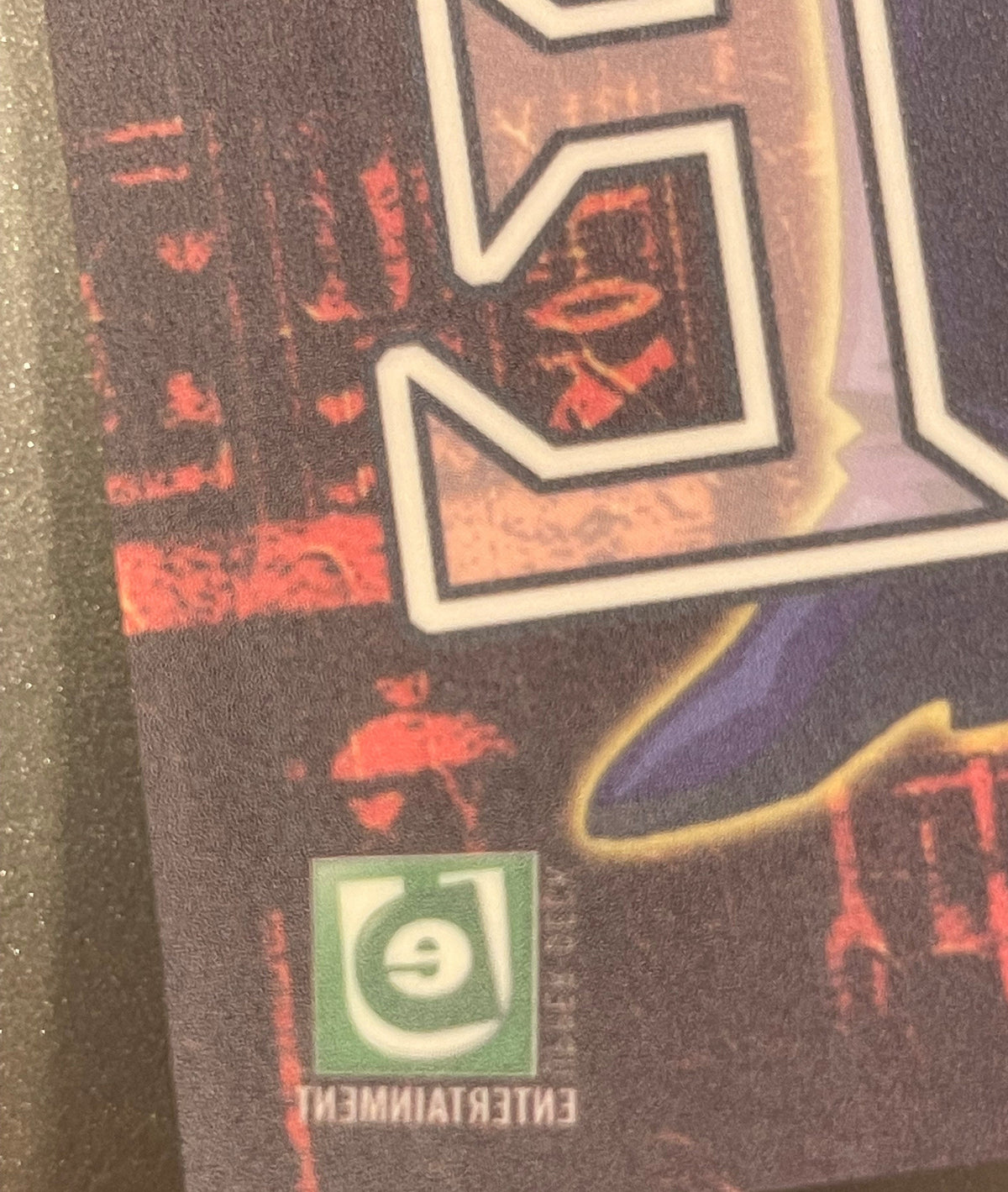 Close-up of retro Yu-Gi-Oh! window cling showing red characters, white-bordered frames, purple section, and green