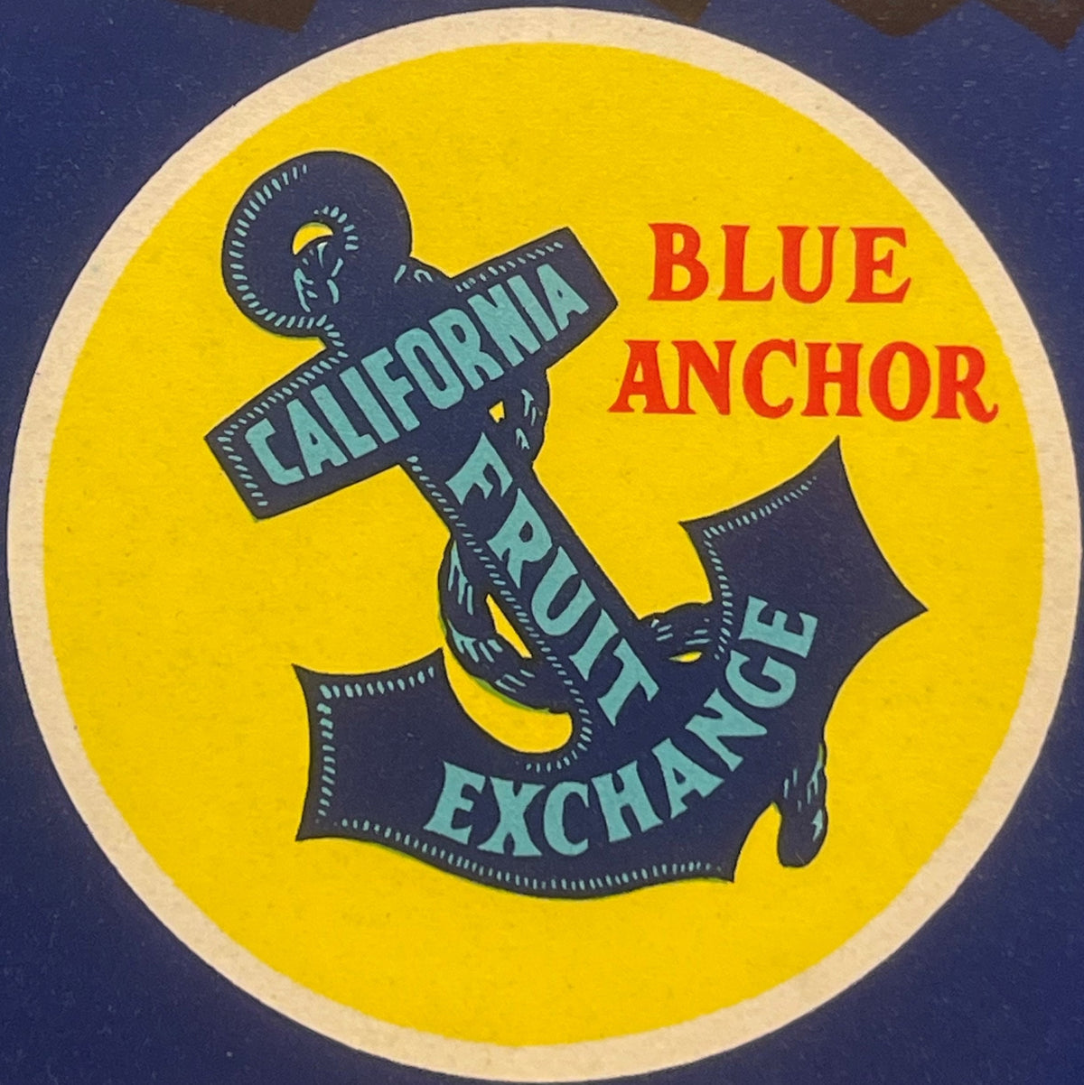 Circular vintage fruit crate label with yellow background, dark anchor design, and red and teal text reading "Blue Anchor" an