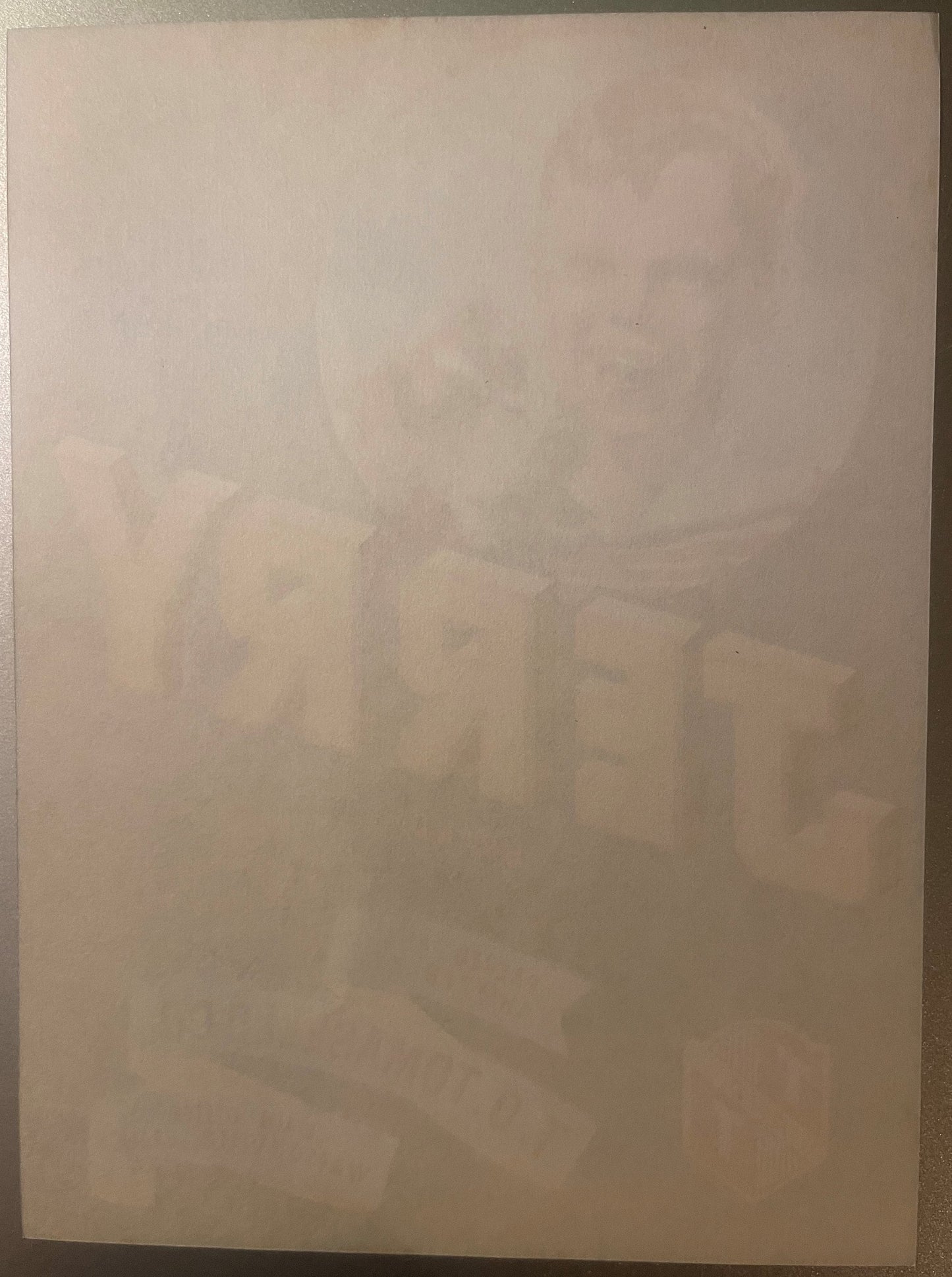 Faded vintage crate label with dog illustration and text, laid flat on tan surface, heavily aged and difficult to read