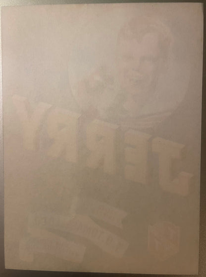 Faded vintage crate label with dog illustration and text, laid flat on tan surface, heavily aged and difficult to read