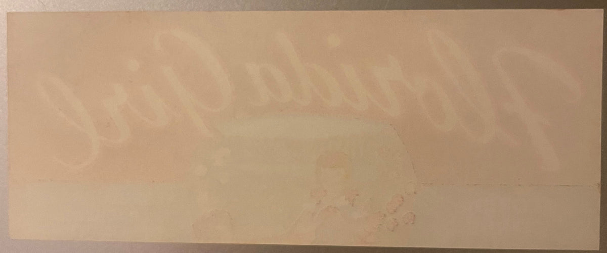 Cream-colored vintage citrus crate label with faint printed text and imagery, showing wear and age marks on paper surface