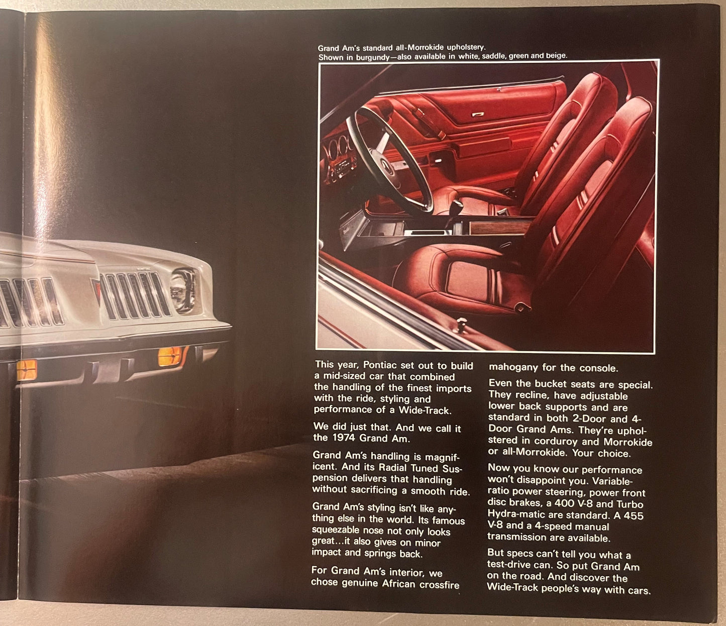 1974 Pontiac Grand Am sales brochure page showing red Morrokide interior with bucket seats and steering wheel, alongside exte