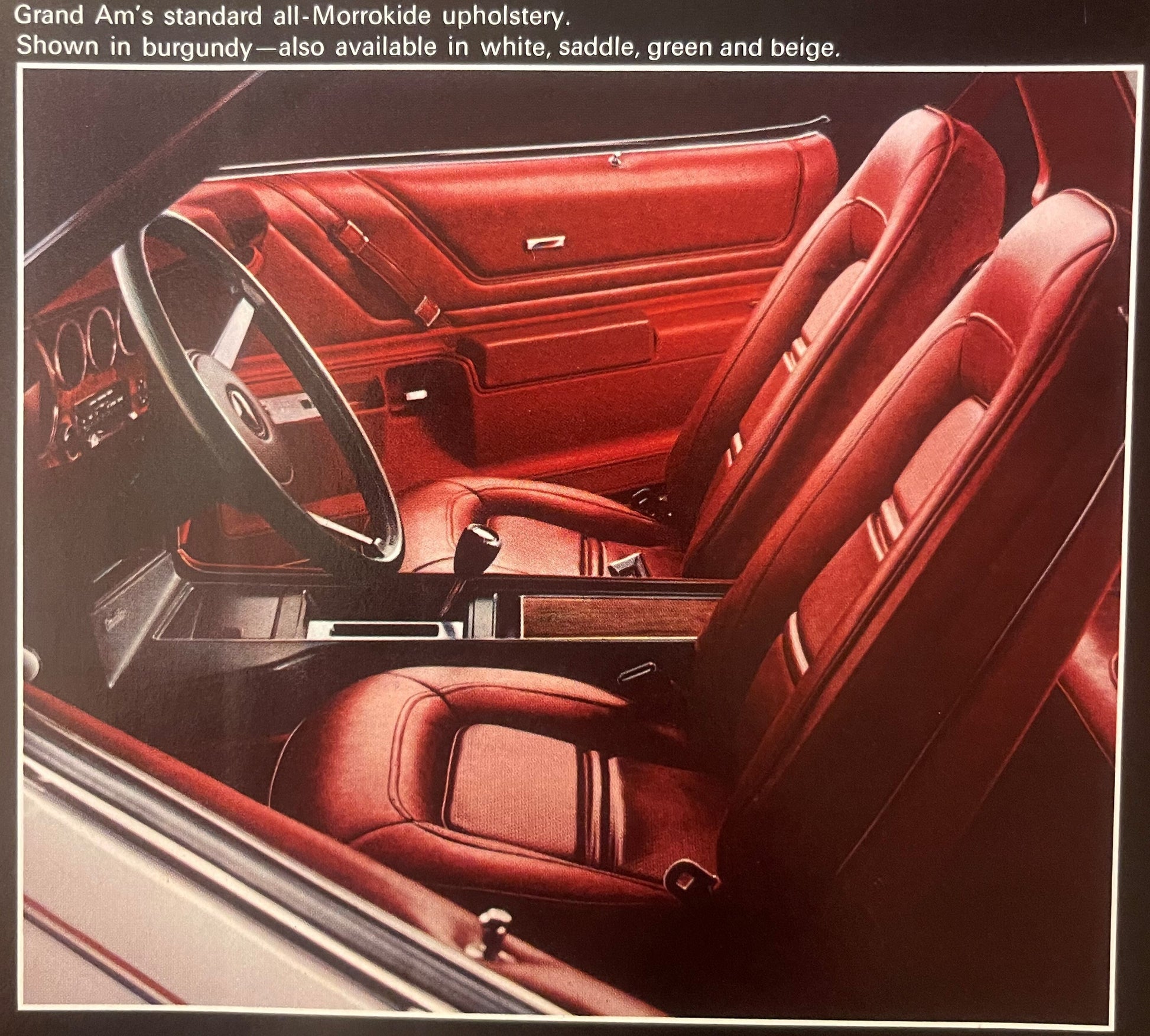 Interior view of red Morrokide upholstery in a Grand Am, showing burgundy seats, door panels, steering wheel, and dashboard