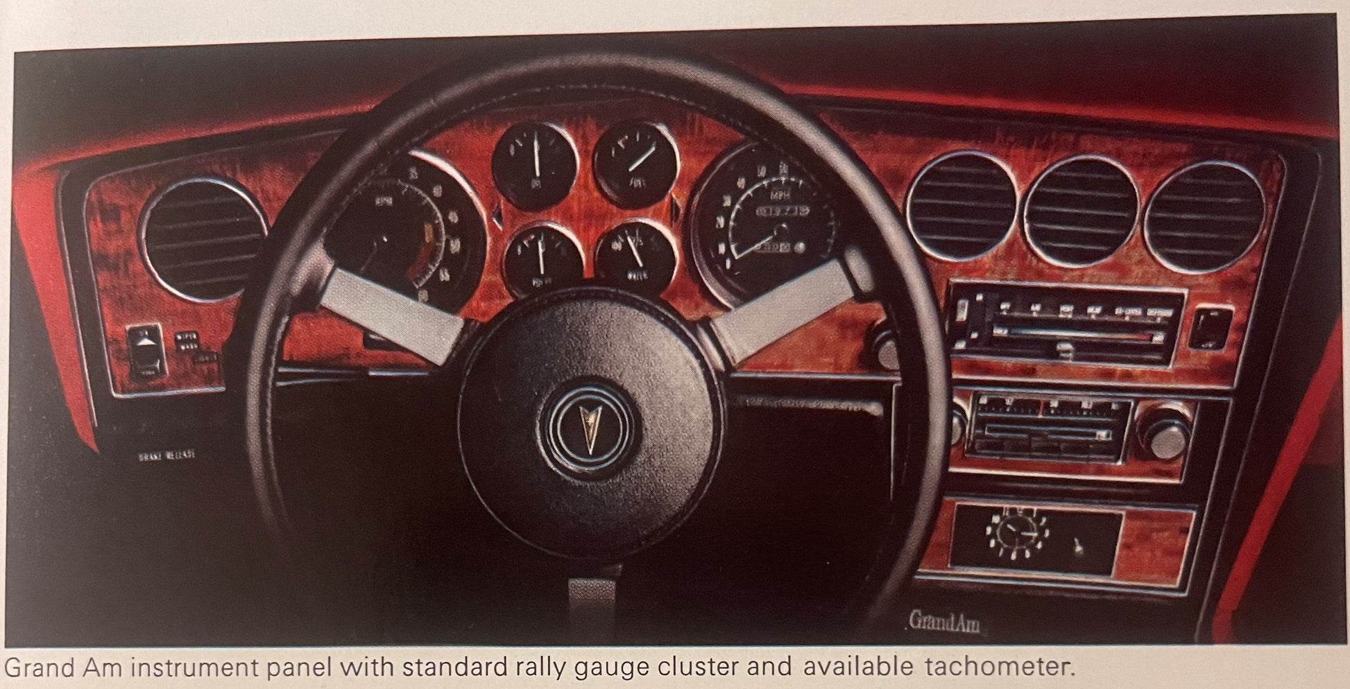 Pontiac Grand Am dashboard with red interior, steering wheel, gauges, and air vents from dealer brochure