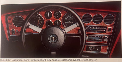 Pontiac Grand Am dashboard with red interior, steering wheel, gauges, and air vents from dealer brochure