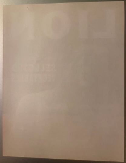 Blank cream-colored vintage crate label photographed at an angle against a dark surface, showing wear and discoloration consi