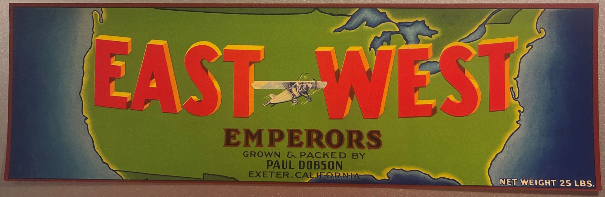 Vintage green crate label reading "East West Emperors Paul Dobson Exeter California 25 lbs" with monoplane.