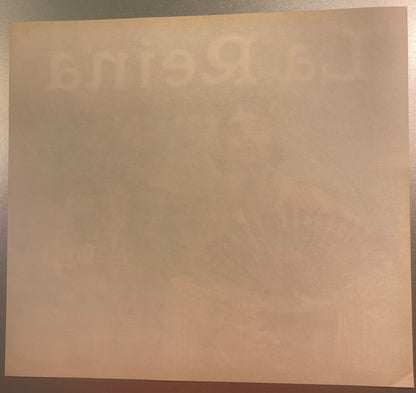 Cream-colored vintage orange crate label with faint embossed or printed text, displayed flat on a beige surface for documenta