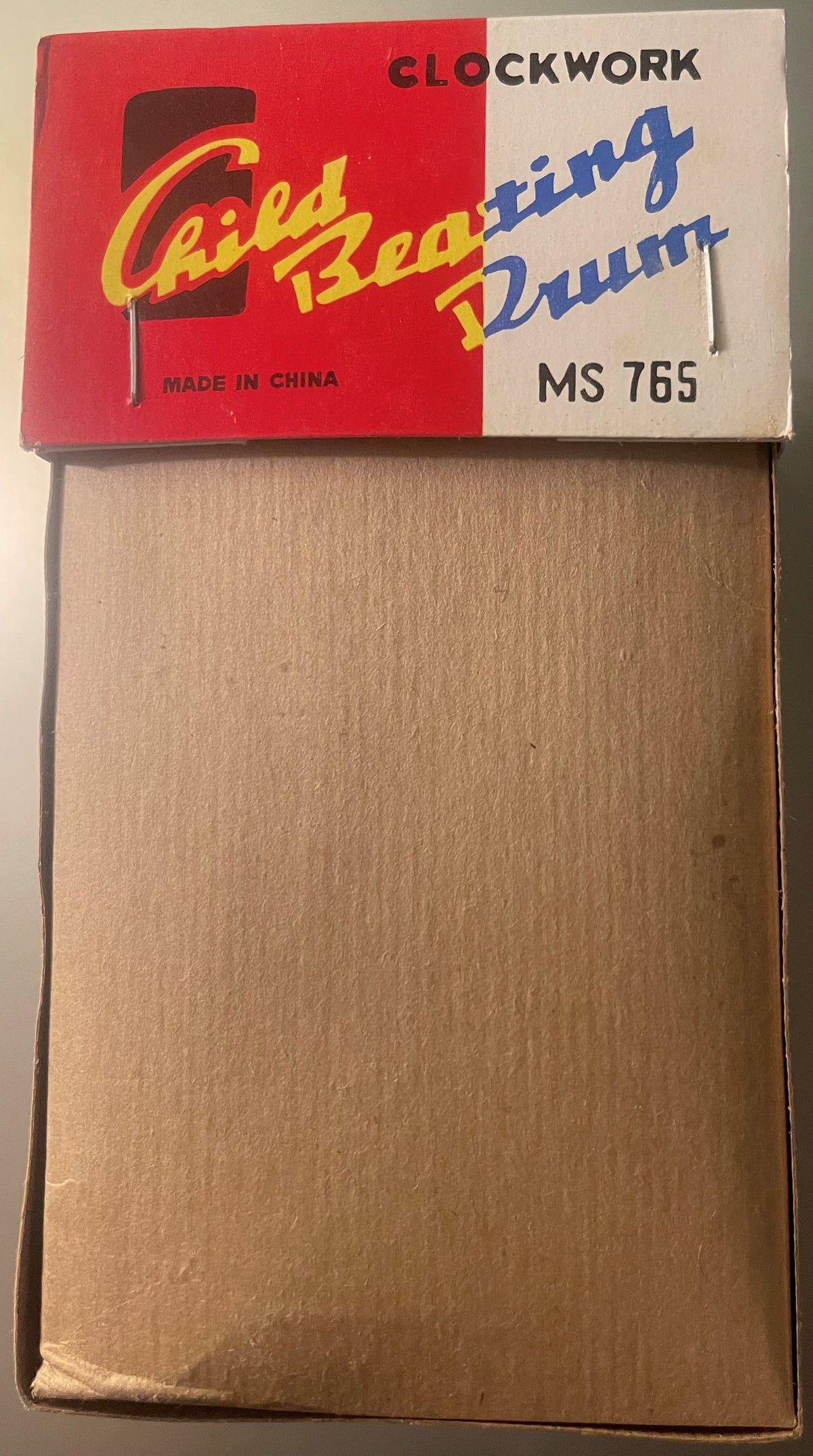 Vintage clockwork tin toy box with red and cream label reading "Clockwork Caid Beating Drum" model MS 765, made in China