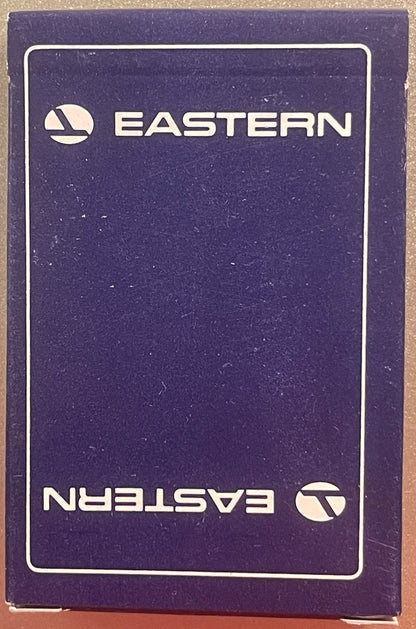 Purple Eastern Air Lines playing card box with white logo and text, shown front-facing on tan surface with visible wear.