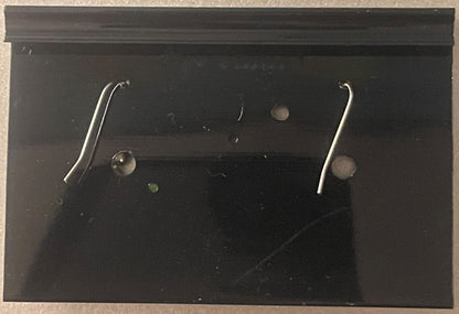 Pair of silver curved hook earrings displayed on black card backing with small round fasteners visible