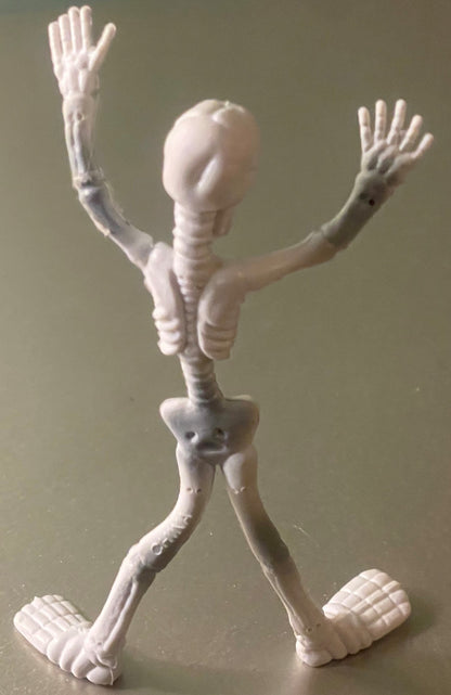 White poseable skeleton figure with articulated limbs and joints, arms raised, standing against neutral background