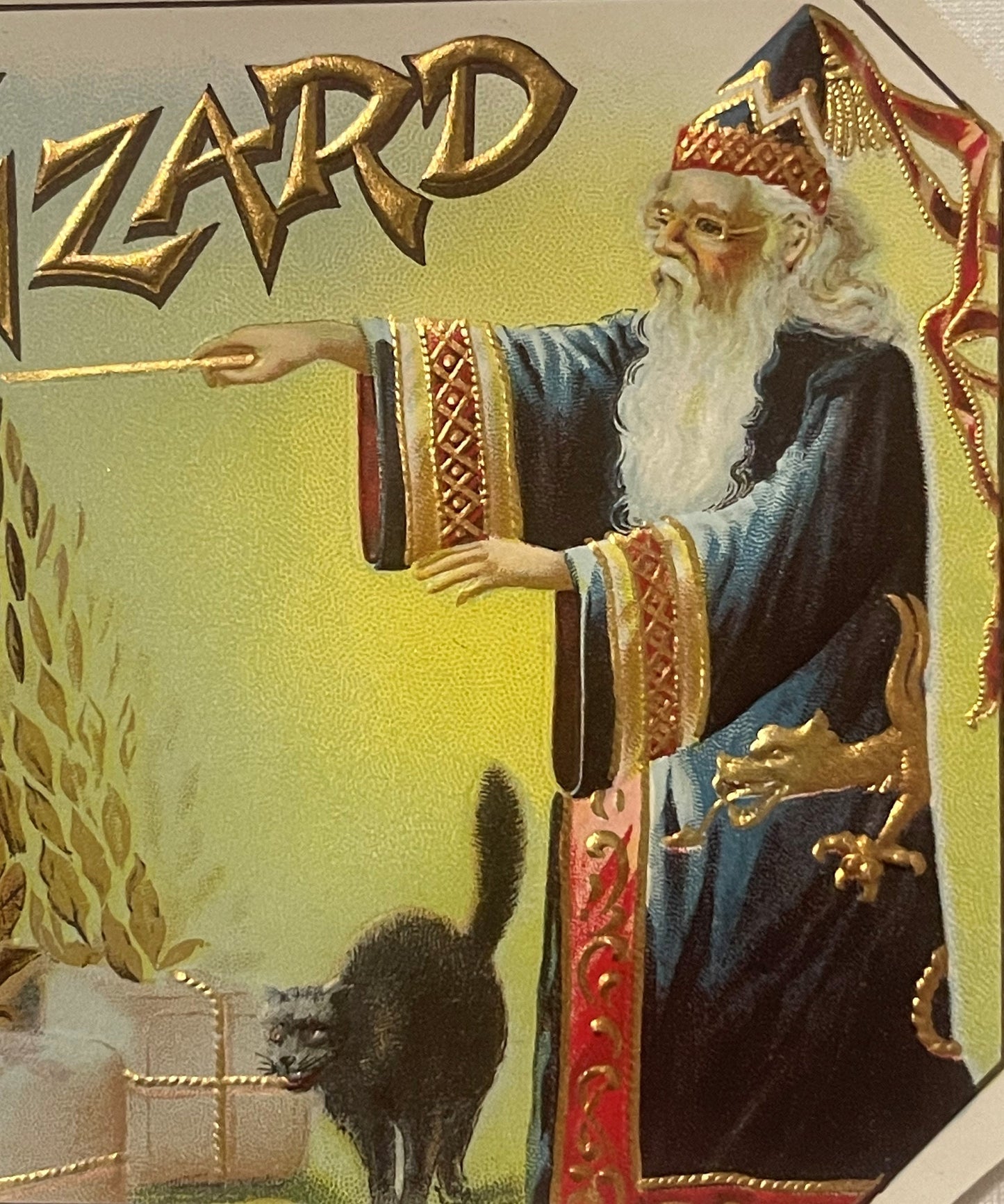 Vintage cigar box label featuring a bearded wizard in blue robes with gold embossed lettering reading "ZARD" and a black cat,