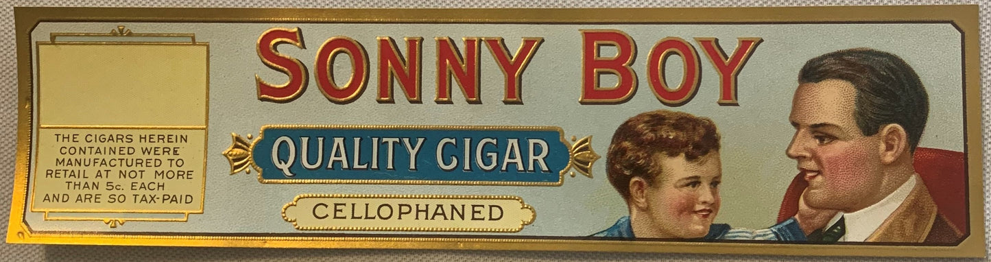 Vintage Sonny Boy Quality Cigar cigar box label showing two men's portraits and embossed cellophane text on cream background.