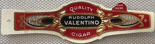 Ornate red and gold cigar band label reading "Rudolph Valentino Quality Cigar" with decorative eye motifs, displayed flat aga