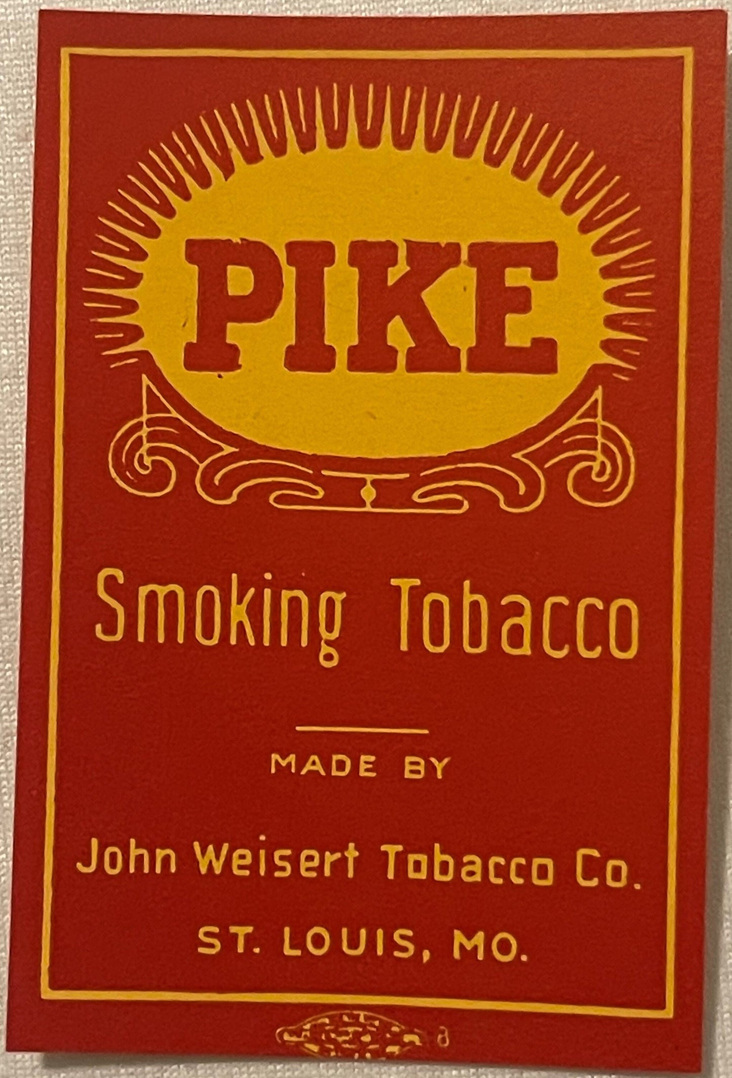 Vintage Pike Smoking Tobacco label with red and gold design, sun motif, and ornamental scrollwork, made by John Weisert Tobac