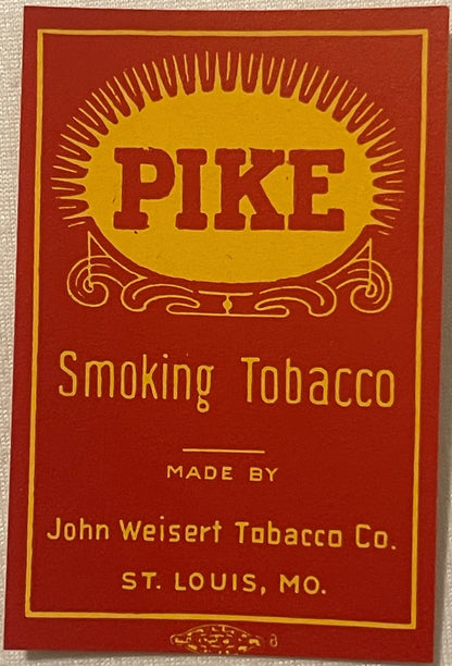 Vintage Pike Smoking Tobacco label with red and gold design, sun motif, and ornamental scrollwork, made by John Weisert Tobac