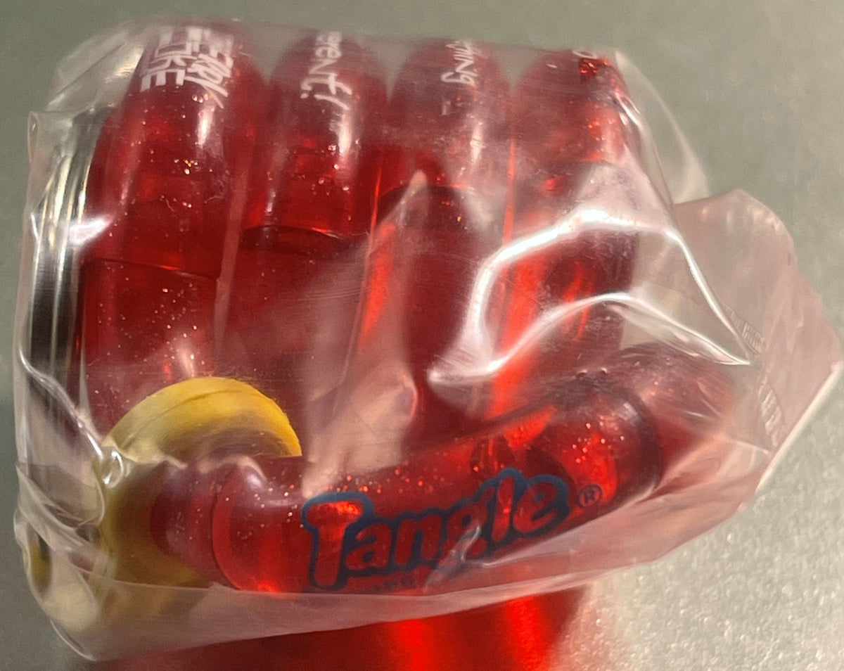 Sealed plastic package containing four red Cherry Coke bottles with yellow lemon slice charm, Tangle logo visible on front, s