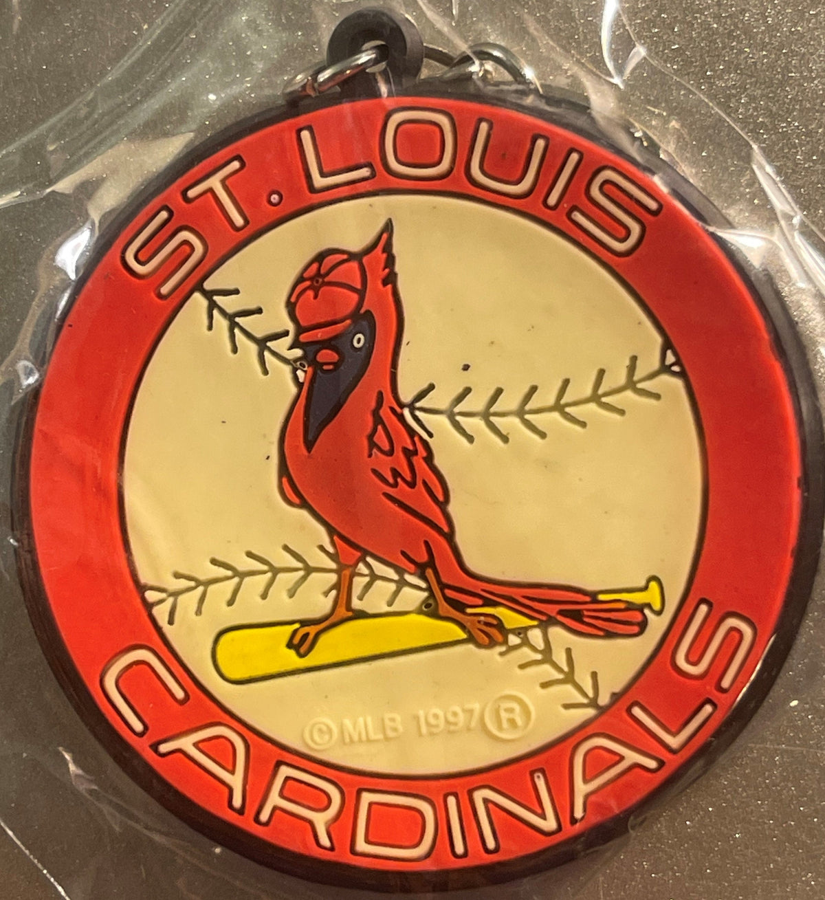 Red and cream circular keychain with St. Louis Cardinals logo featuring cardinal bird on yellow baseball bat, surrounded by r