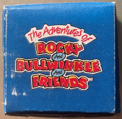 Blue box with red and yellow "The Adventures of Rocky and Bullwinkle and Friends" logo text, shown front-facing against tan b