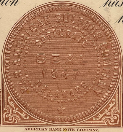 Brown engraved circular frame with wavy line fill pattern and ornamental corners, labeled "American Bank Note Company" at bot