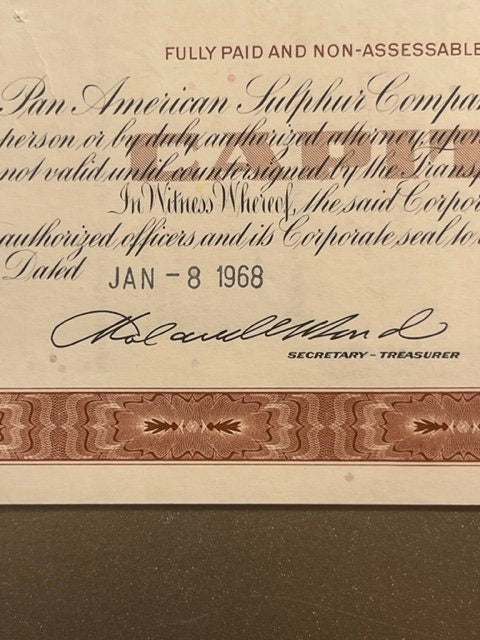 Close-up of vintage stock certificate corner showing "JAN-8 " date stamp, signature line labeled "SECRETARY-TREASURER," a