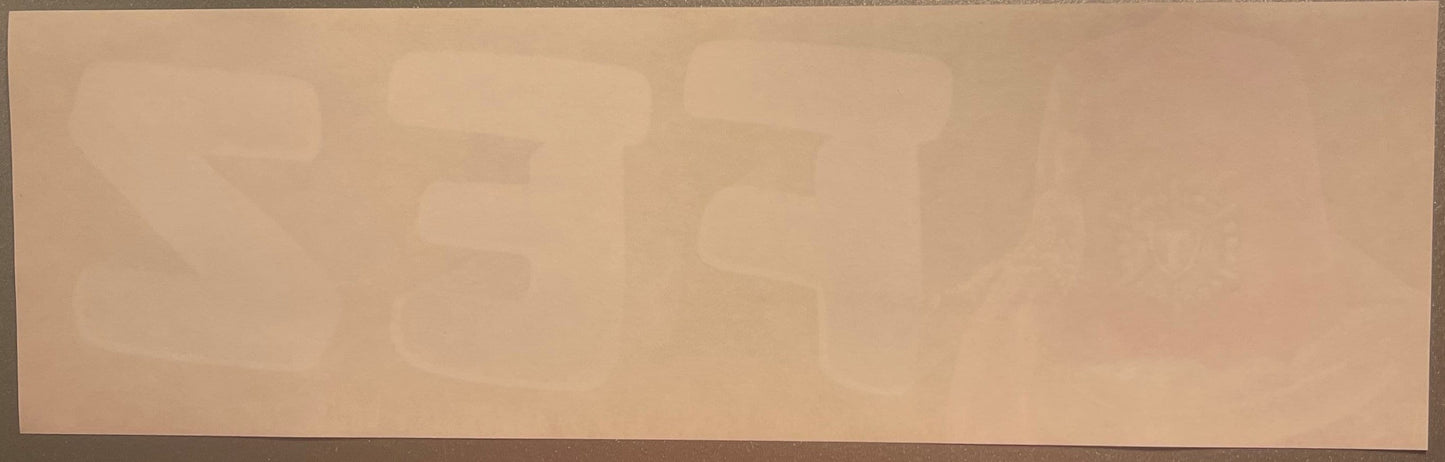 Faded vintage crate label with tan background and barely visible embossed text and decorative design, photographed flat again