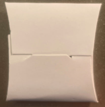 White unopened rectangular box with horizontal seam line across center, photographed straight-on against neutral background