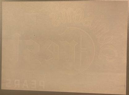 Cream-colored vintage pear crate label with faint embossed imagery of pears and decorative elements, photographed flat agains