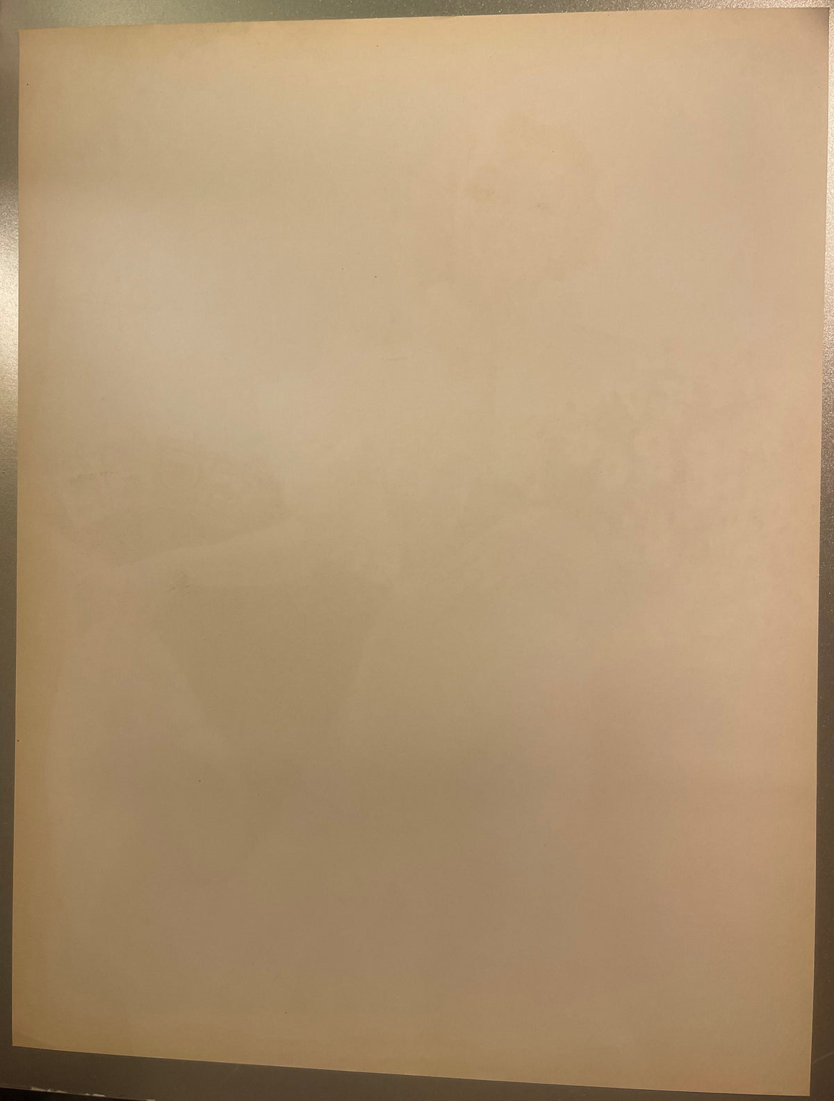 Blank cream-colored page of vintage lithograph, photographed at slight angle against gray surface for scale
