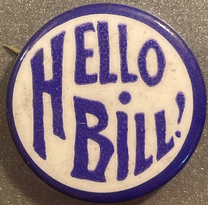 Purple and white celluloid pinback button with "HELLO BILL!" text in large letters, shown flat against textured gray surface