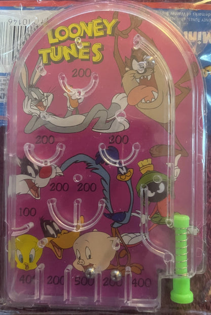 Vintage pink Looney Tunes mini pinball machine with clear plastic cover, featuring Bugs Bunny, Road Runner, Tweety and other 