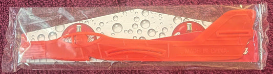 Orange plastic telephone handset in packaging for Y2K Coca-Cola Plane Glider