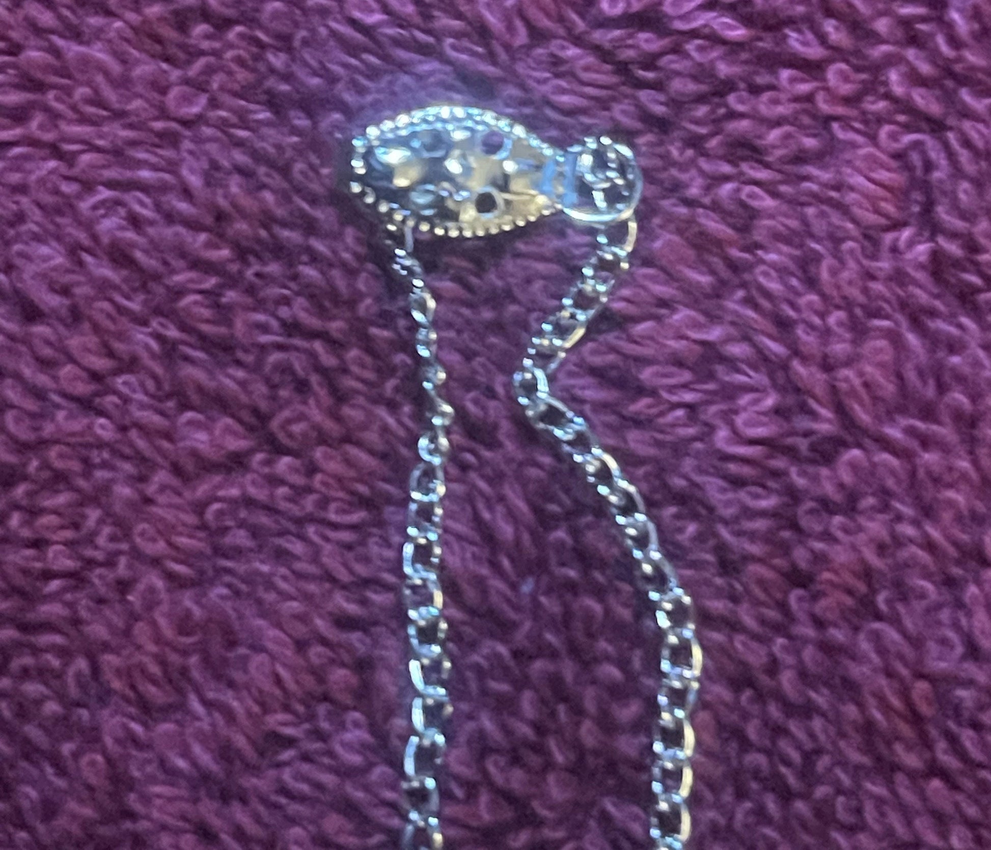 Silver-toned miniature Coca-Cola can pendant on beaded chain necklace, displayed on purple textured fabric