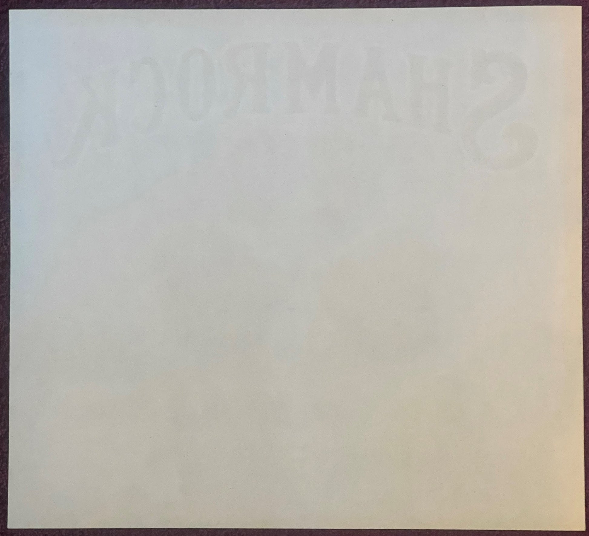 Cream-colored vintage orange crate label with faint Shamrock brand imagery and text visible against light background