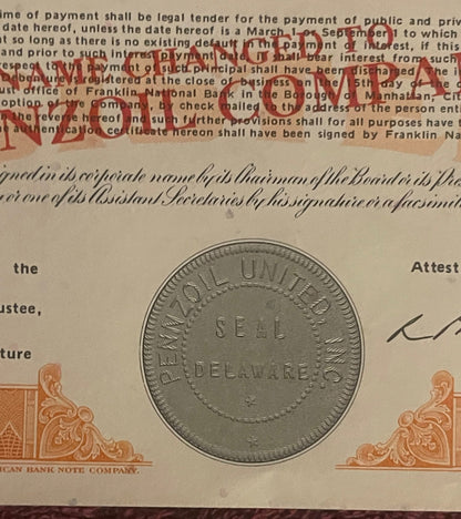 Vintage stock certificate with red "PAID" stamp overlay, ornate corner designs, and a seal coin displayed for scale against p