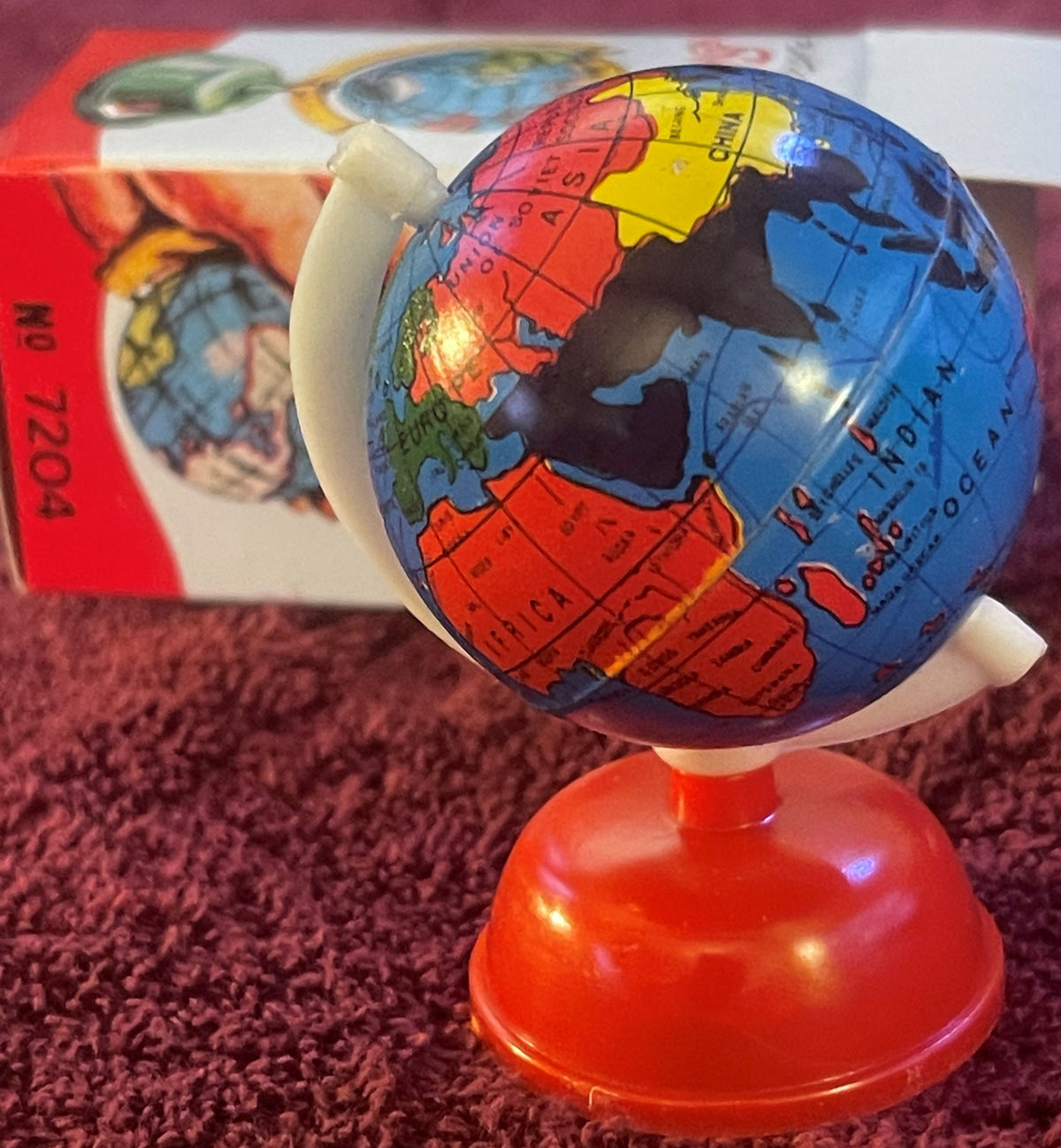 The globe turned to Europe, Africa, the Soviet Union and China, cream meridian and orange-red base, box behind.