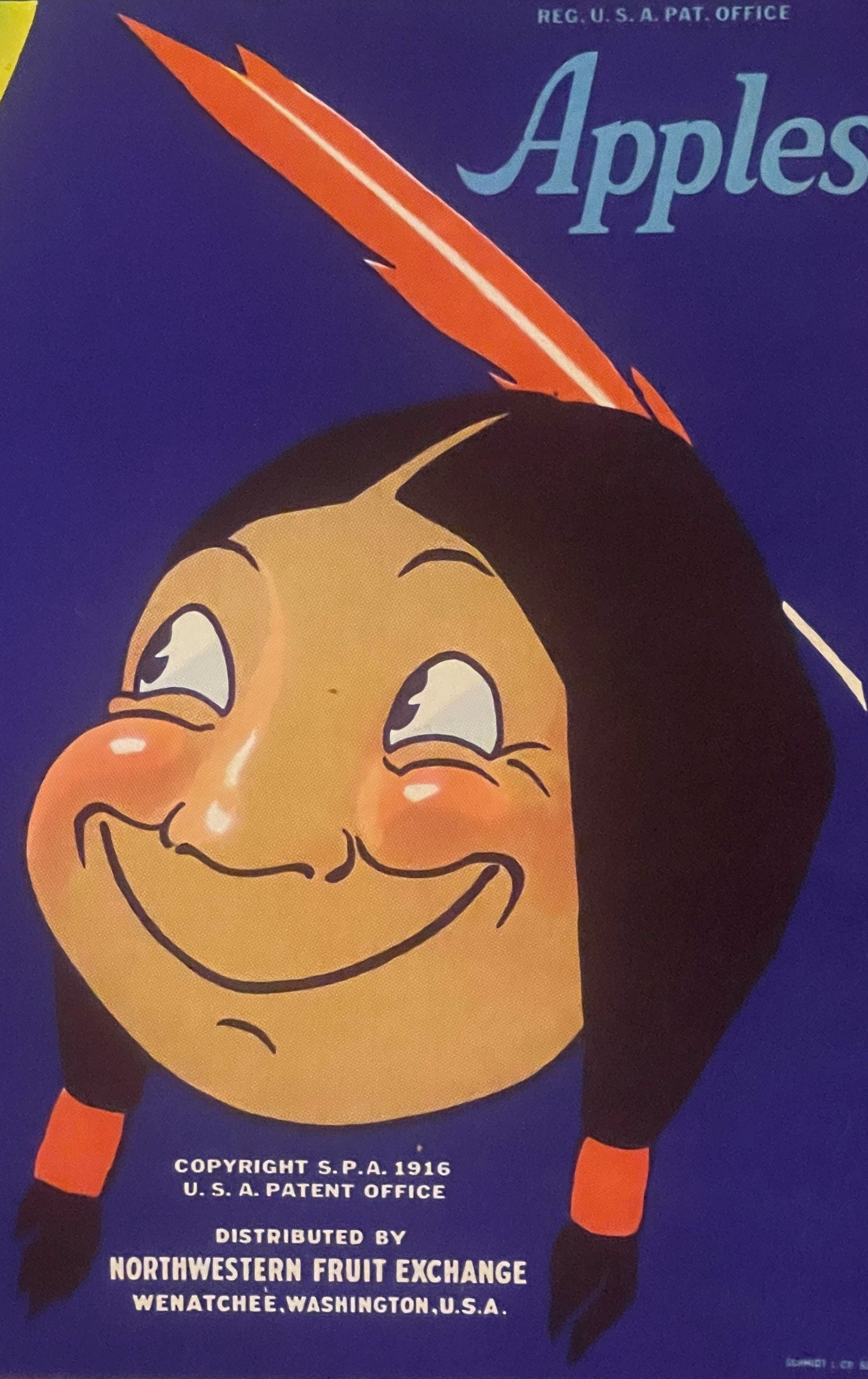 Vintage apple crate label featuring a smiling character with dark hair and orange cheeks wearing a feathered headdress agains