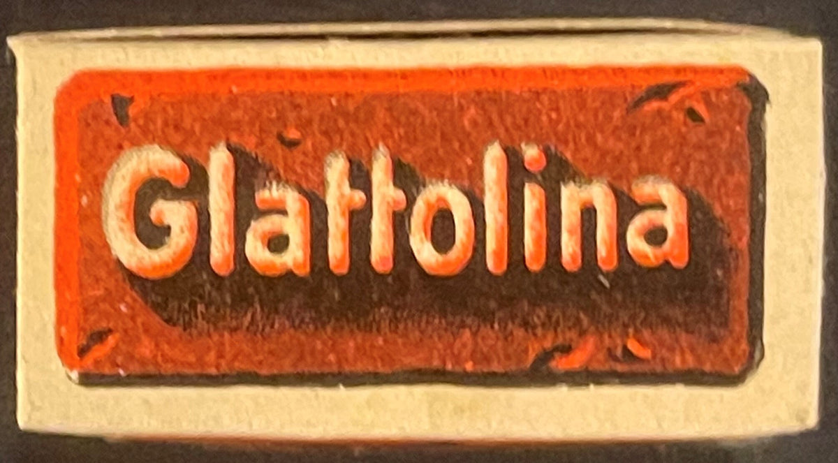 Vintage red and cream cardboard box with embossed white text reading "Glattolina" against orange-red background