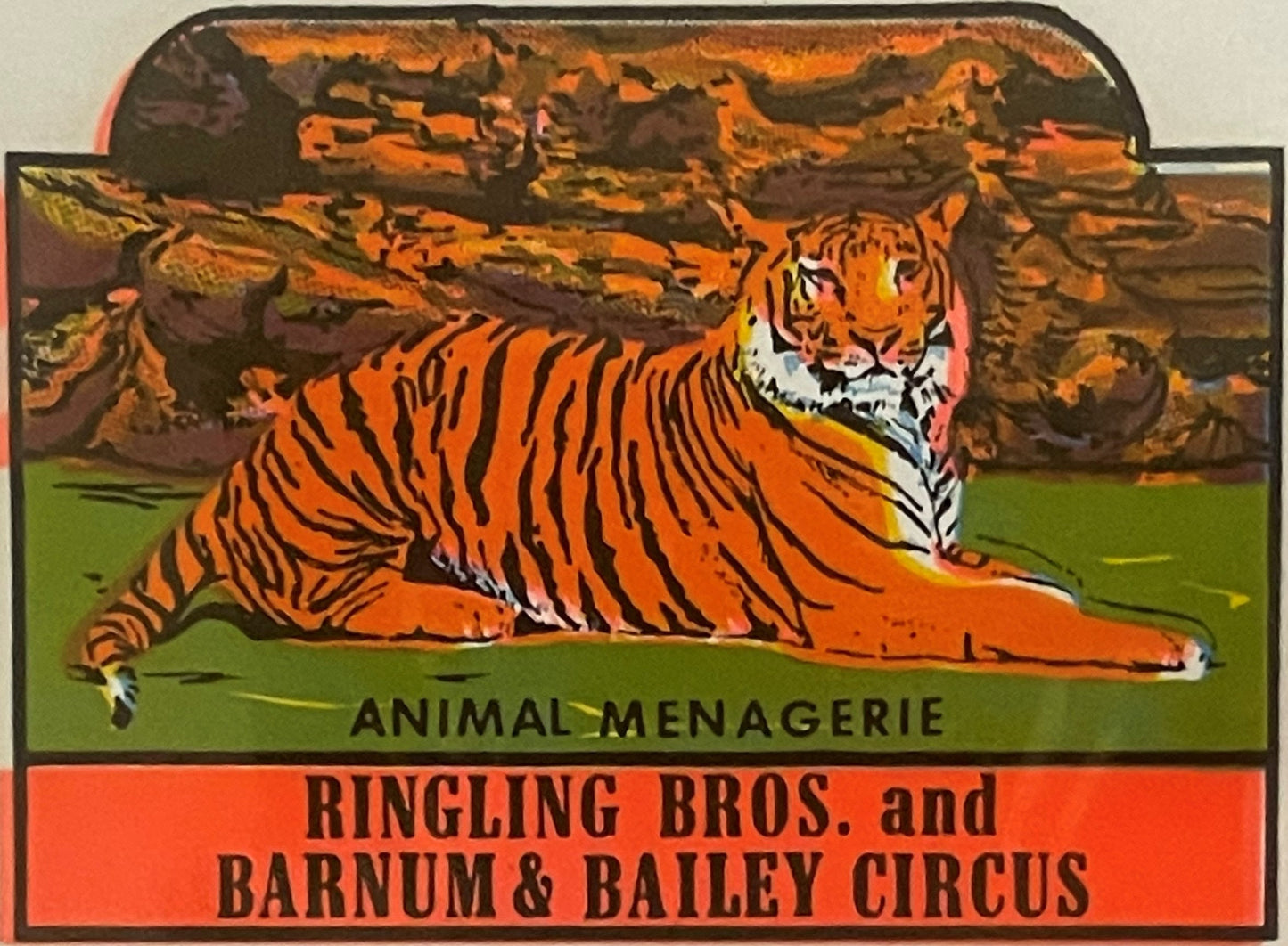Vintage circus decal showing a reclining tiger with orange and black stripes against a green ground and rocky background, lab