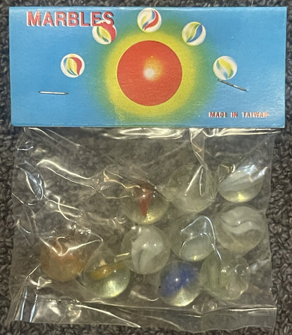 Unopened vintage marbles package with blue box showing red sun and colorful marbles, clear plastic bag containing translucent