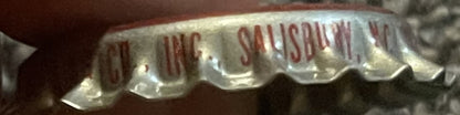 Close-up of vintage bottle cap showing "Caravan Strawberry" text in red on white ridged metal surface