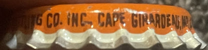 Close-up of orange and white cork bottle cap with embossed text reading "G CO. INC. CAPE GIRARDEAU MO