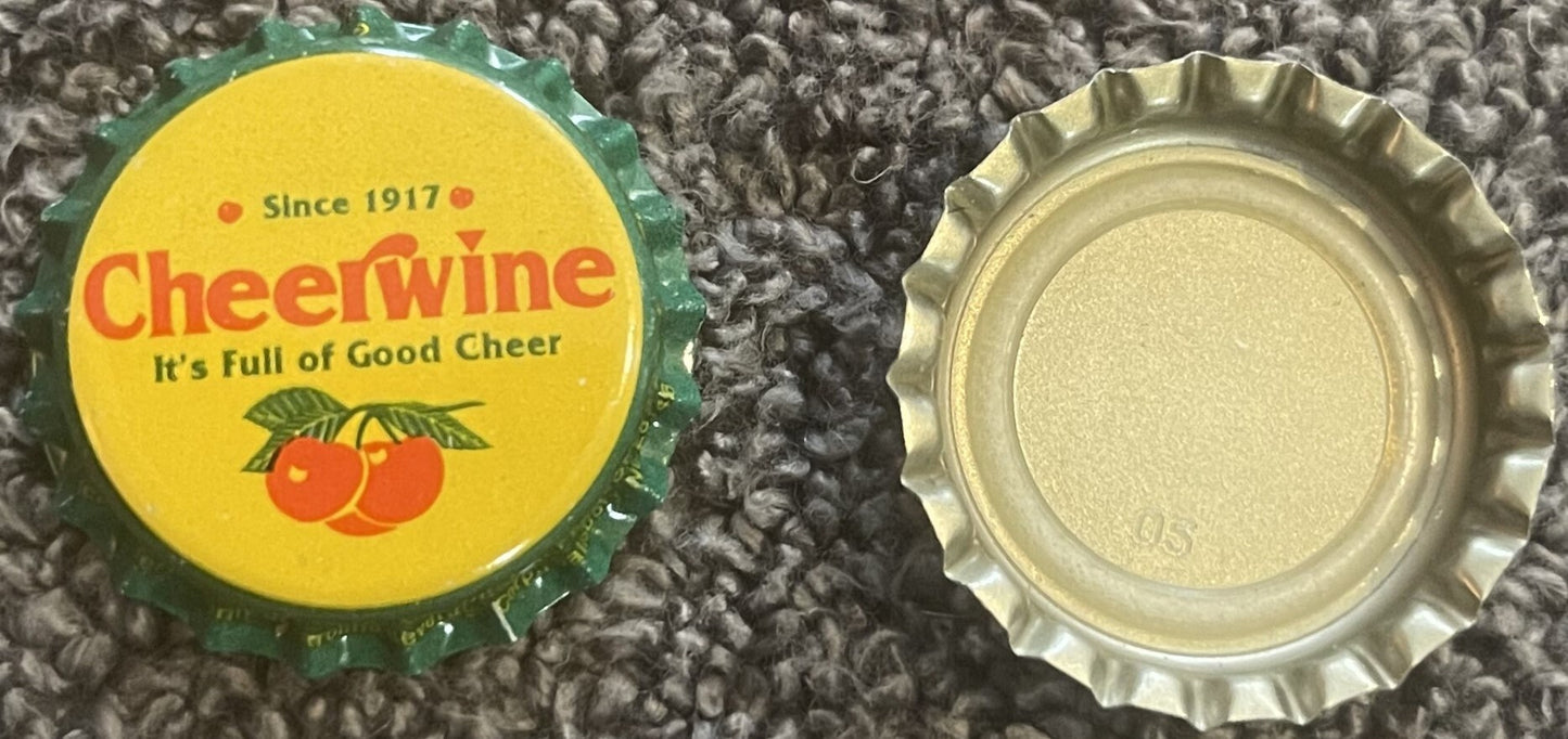 Vintage Cheerwine bottle cap showing yellow label with red text, green border, and cherry illustration, displayed front and b