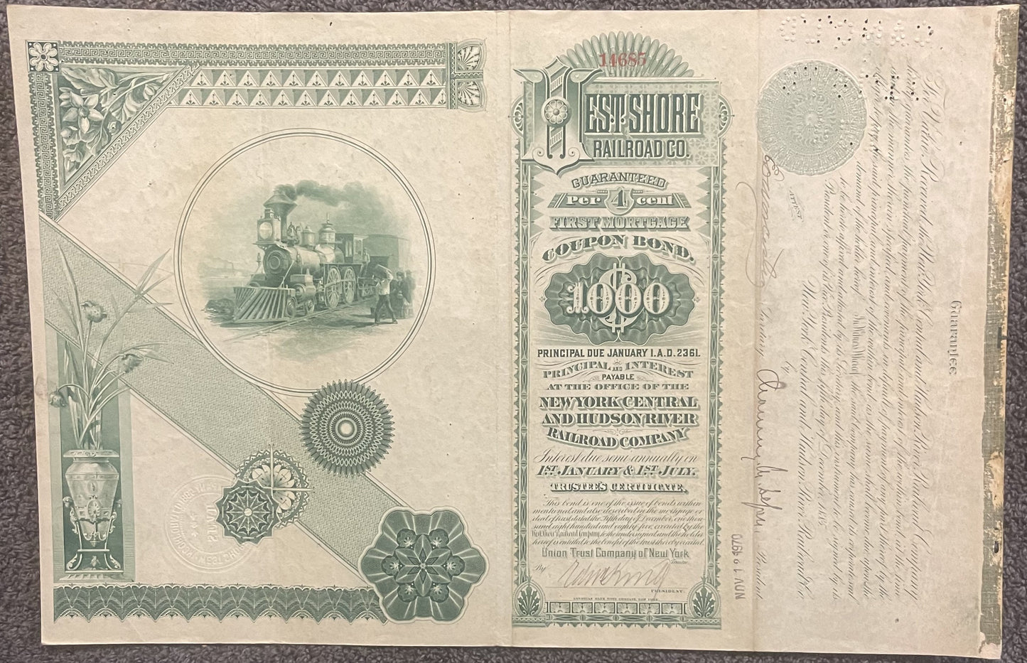 Antique railroad bond certificate with green engraved locomotive vignette, decorative borders, and "$1000" denomination text 