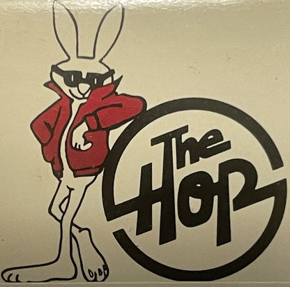 Vintage matchbook cover featuring a stylized white rabbit in a red jacket next to "The Hop" text in a black circle, on tan pa