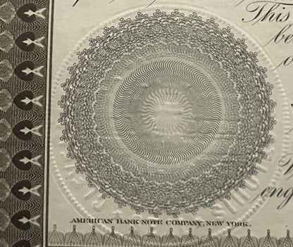 Close-up of ornate circular engraving with concentric wavy lines on antique bond certificate, showing "American Bank Note Com